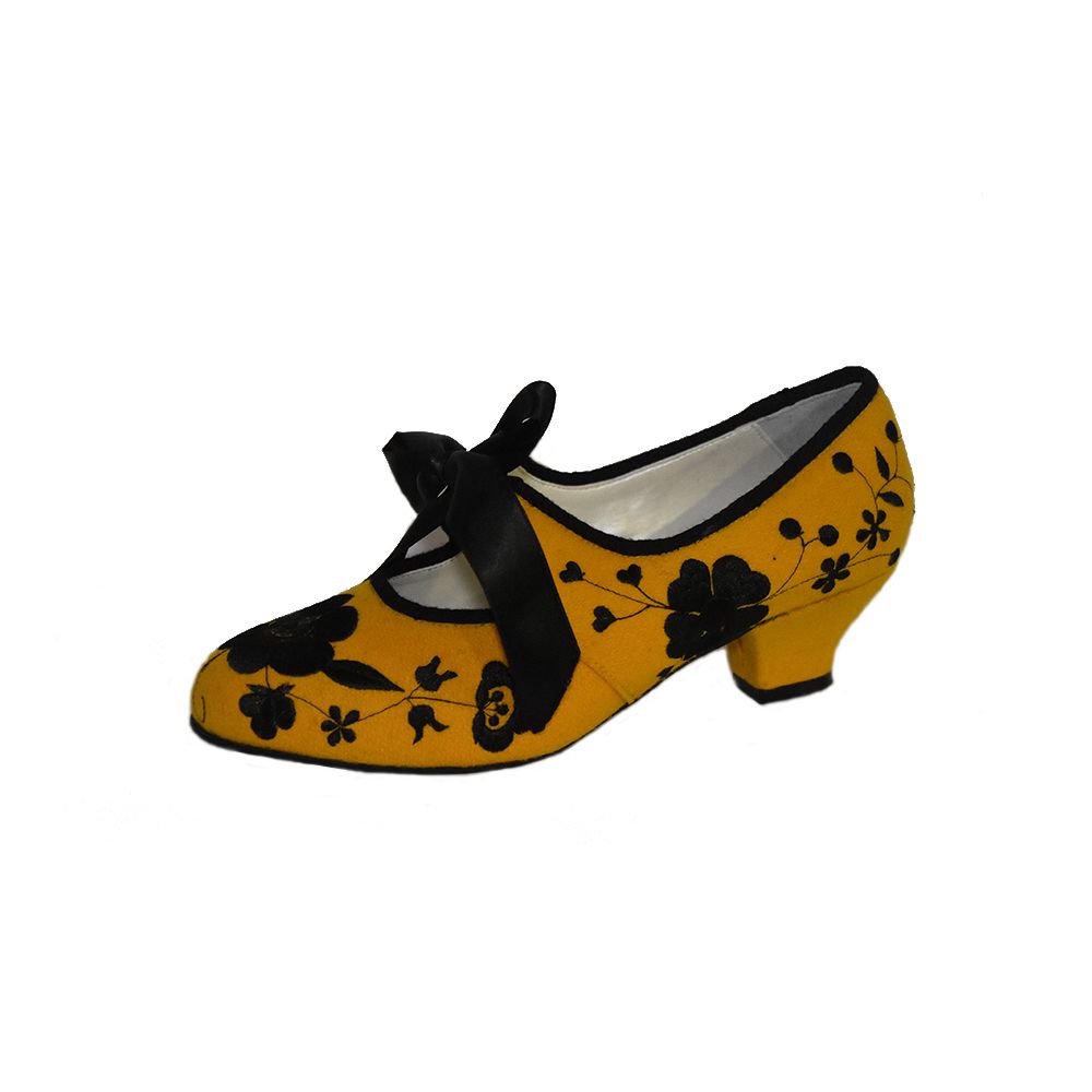 Zapato de piel bordado sobre paño amarillo